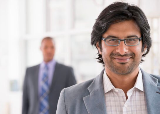 New York City June,USA,A business environment, a light airy city office. Business people. A man in a light jacket wearing glasses.